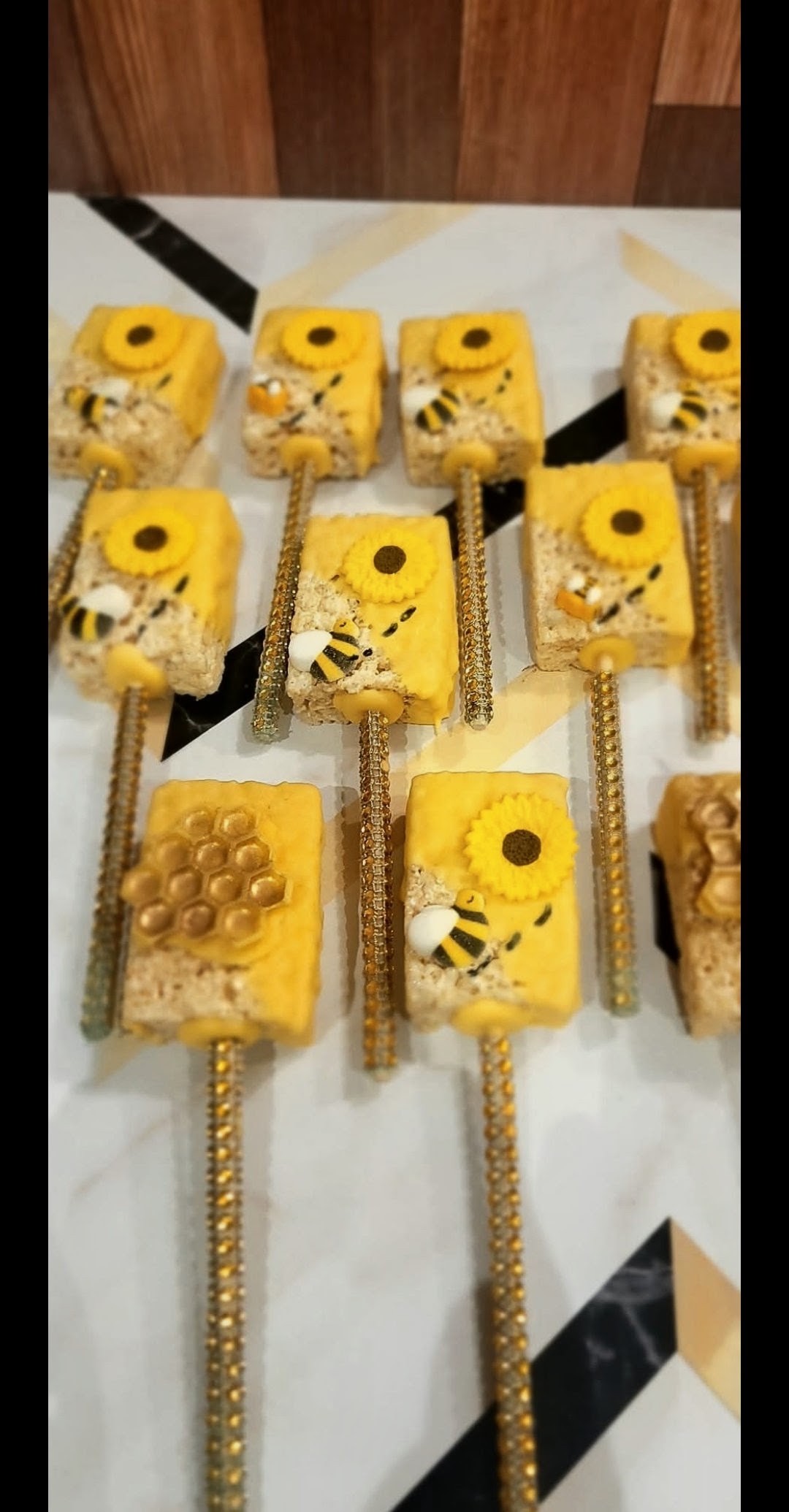 Bee themed rice krispie treats on glitter sticks with sunflowers
