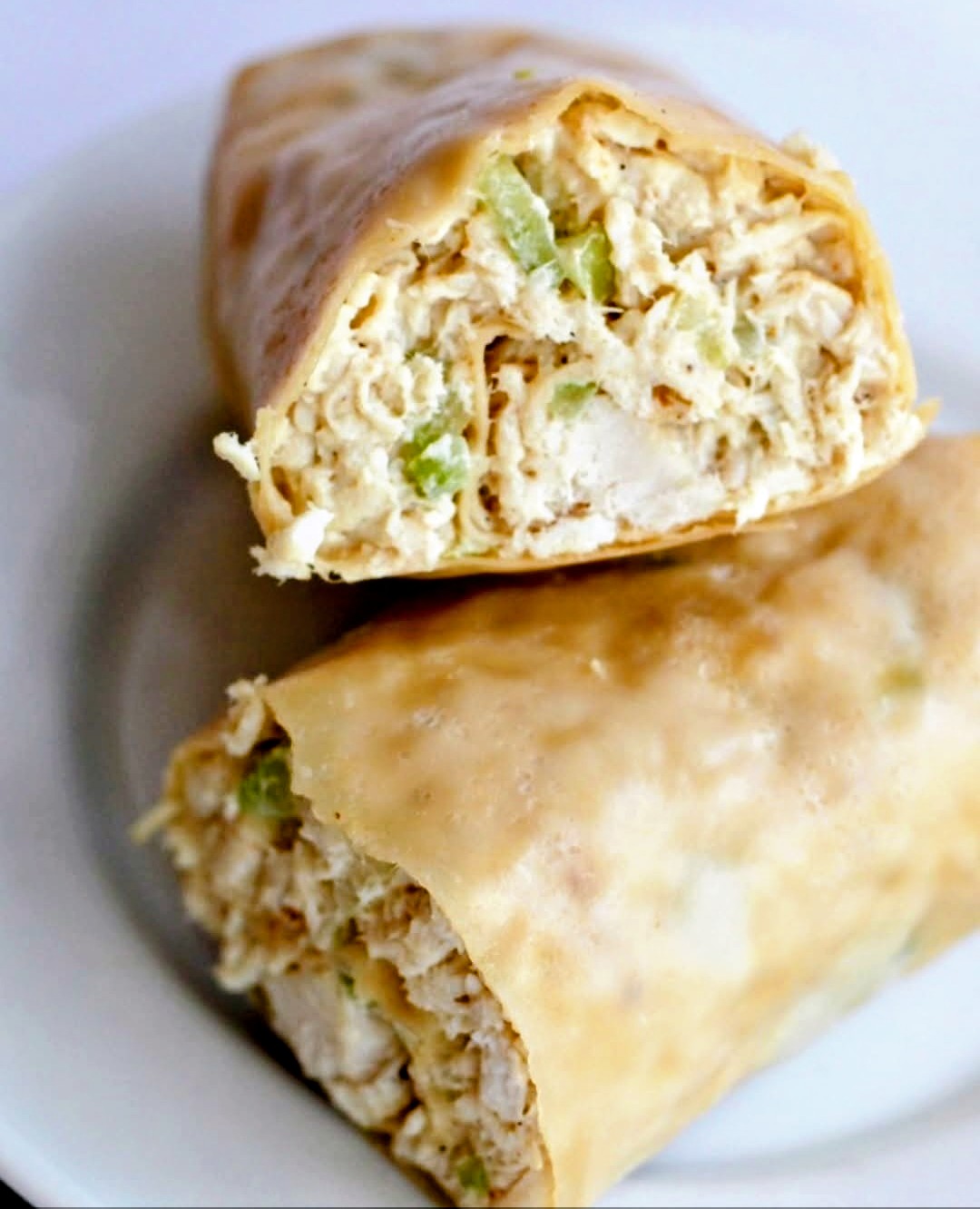 Crispy chicken egg rolls cut open with tender filling