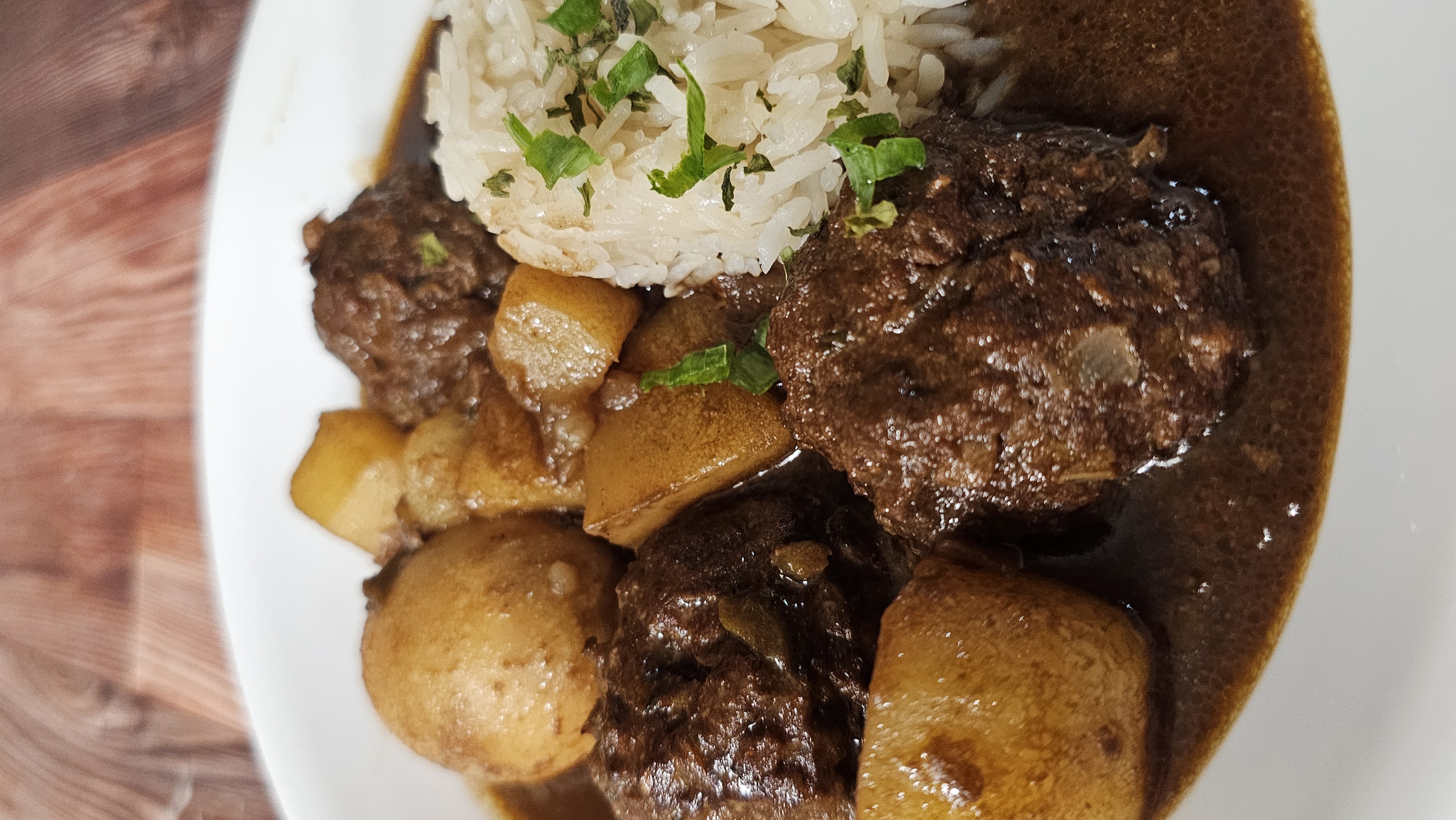 Smothered meatballs and potatoes over rice